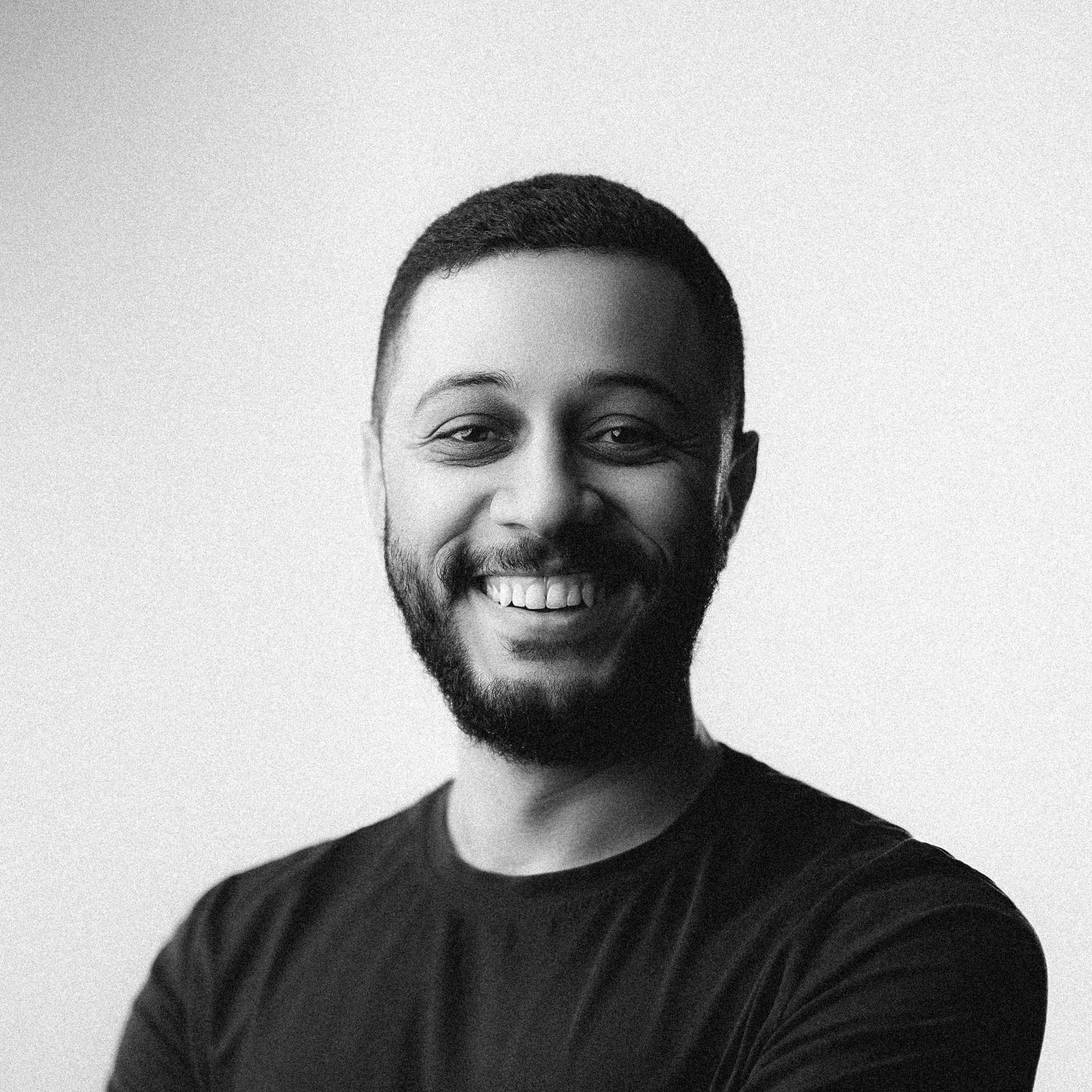 Series of black and white headshots showing man with beard smiling against white backdrop.