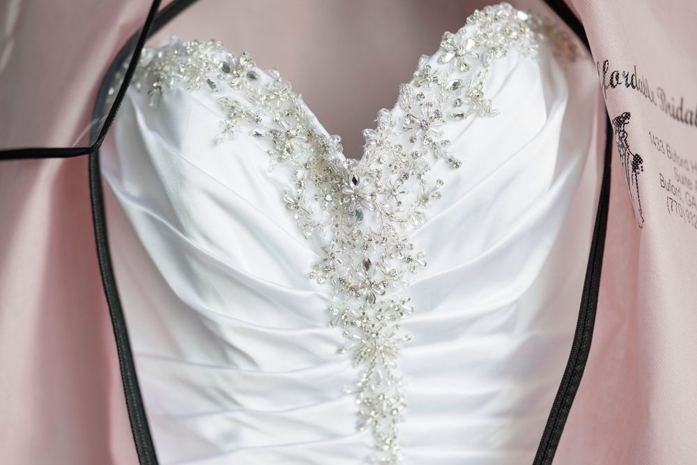 Close-up of white wedding dress bodice with crystal beading and ruched detail.