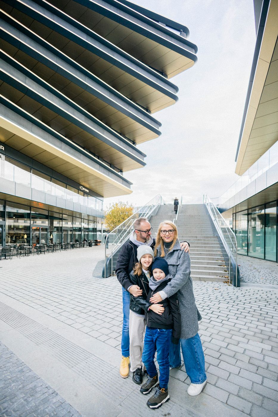 Family group portrait in front of modern architectural building with distinctive horizontal lines.