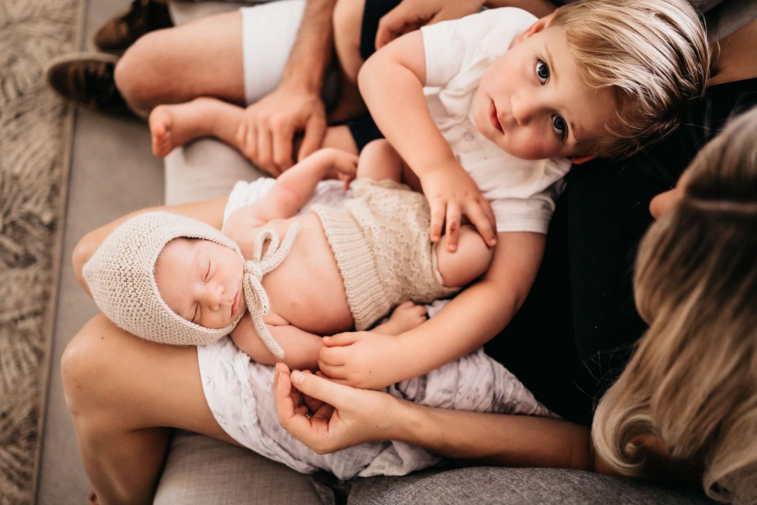 Close-up shots of tender moments between parent and baby in white lace clothing.