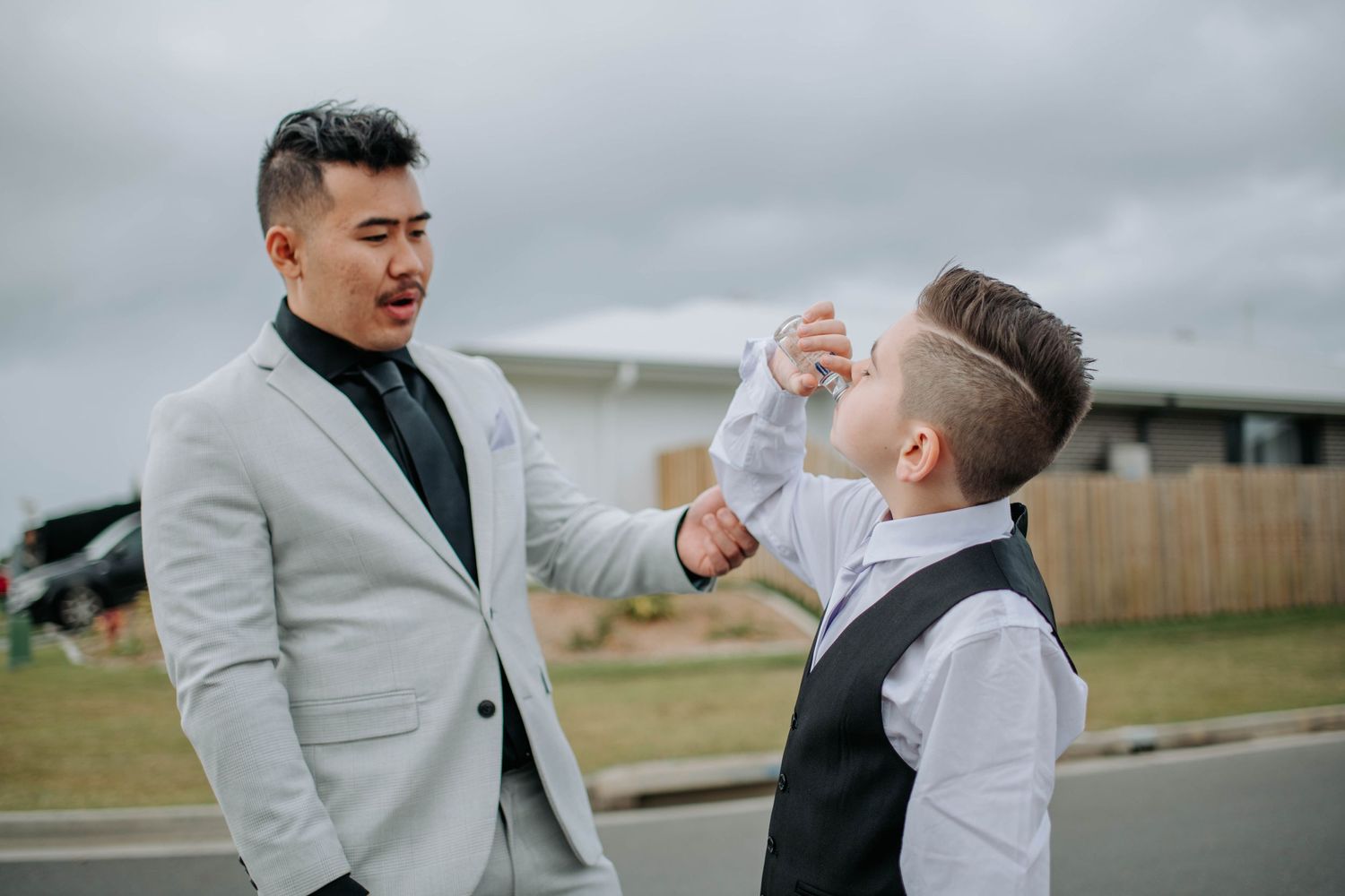 Wedding party member helping adjust another's tie before the ceremony.
