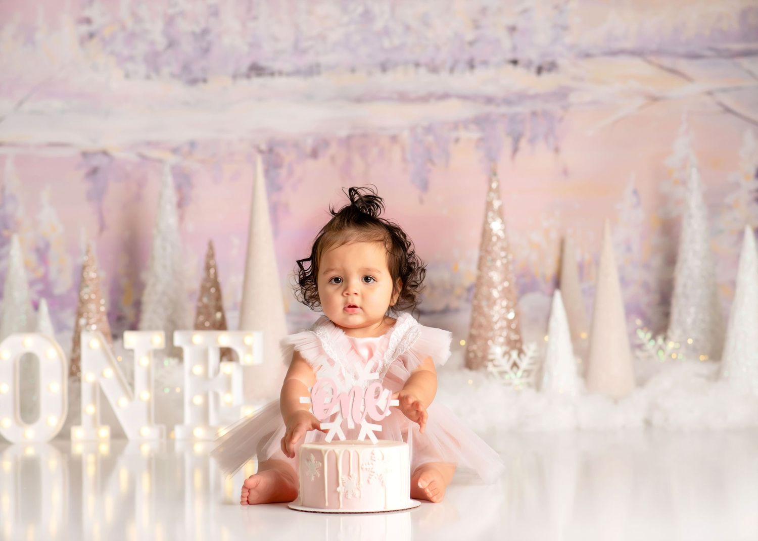 a baby sits curiously behind a cake