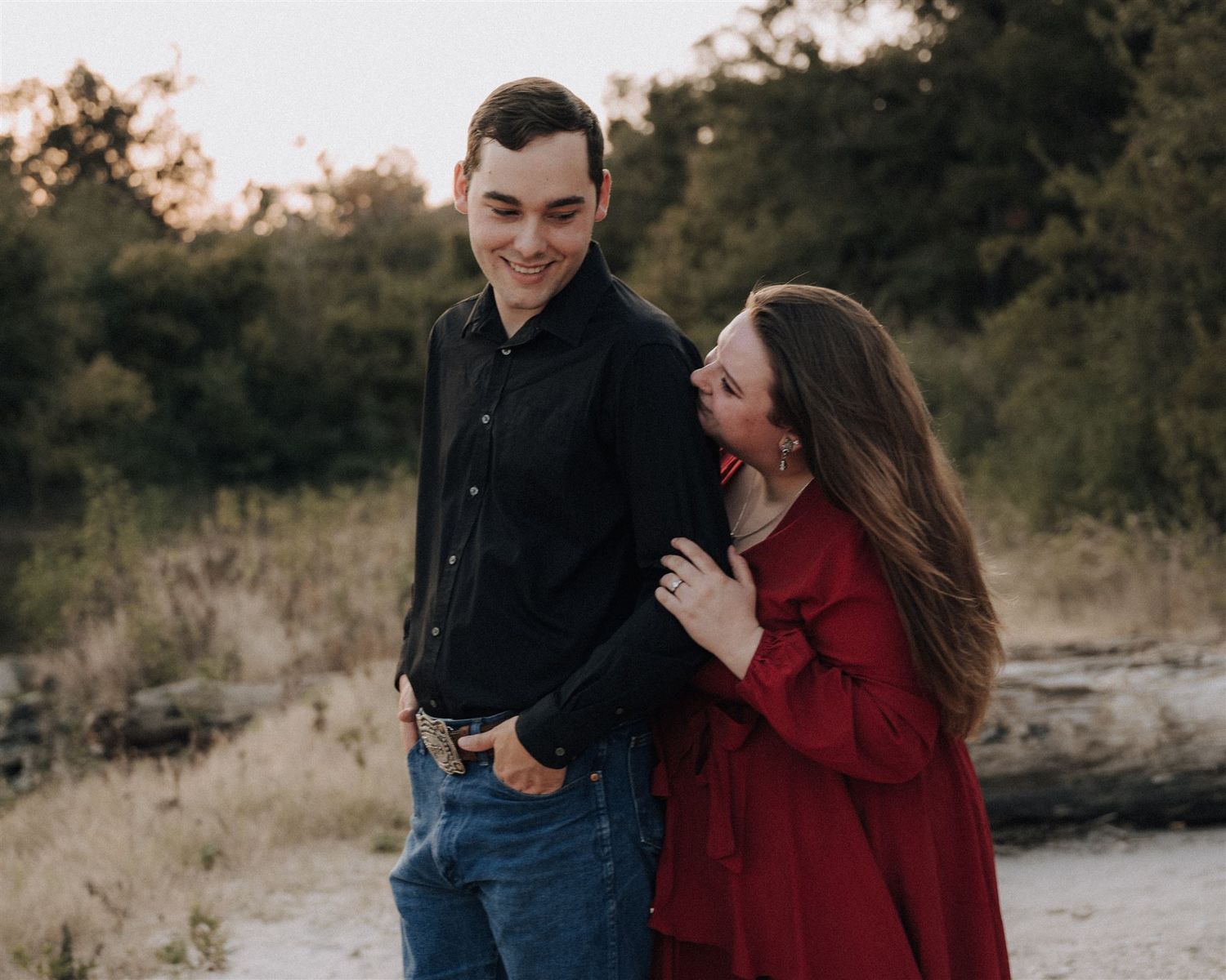 Couple shares a joyful moment together while posing on a natural outdoor trail.