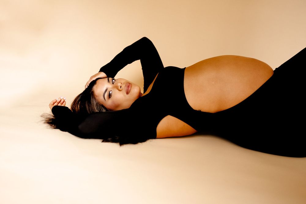 Cool edgy maternity session in tan studio backdrop, black dress maternity