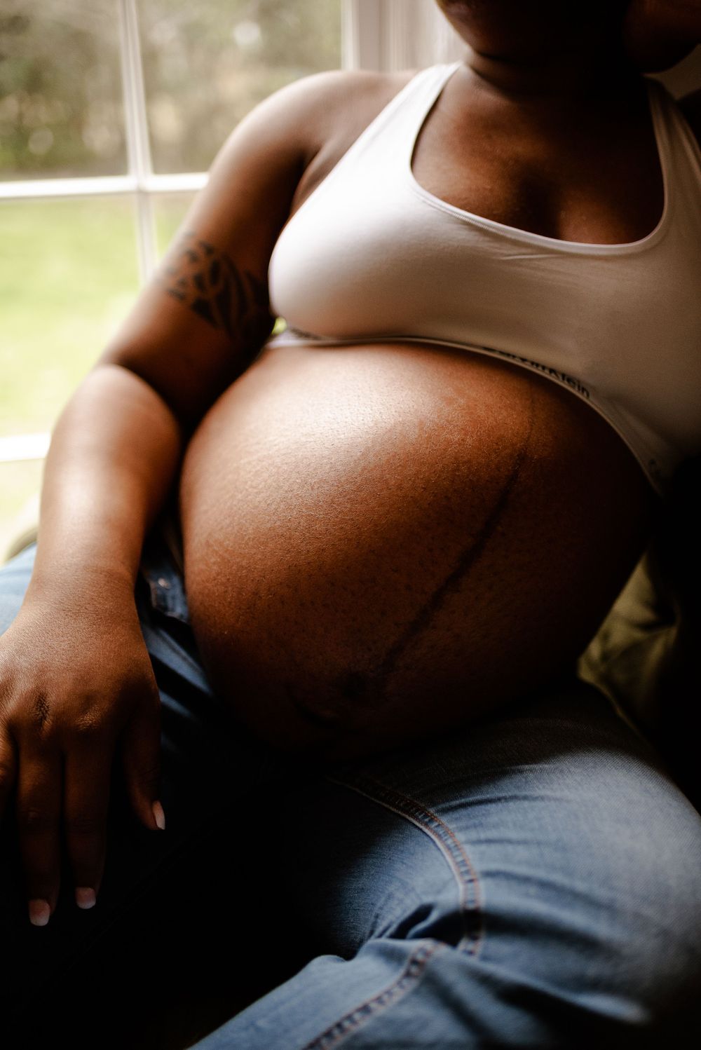 Black woman maternity session in natural light studio casual beautiful