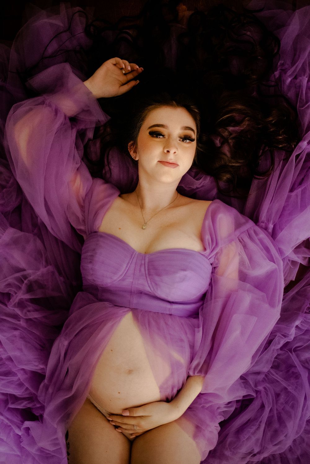 Maternity session with lavender haze dress shot from above in studio.