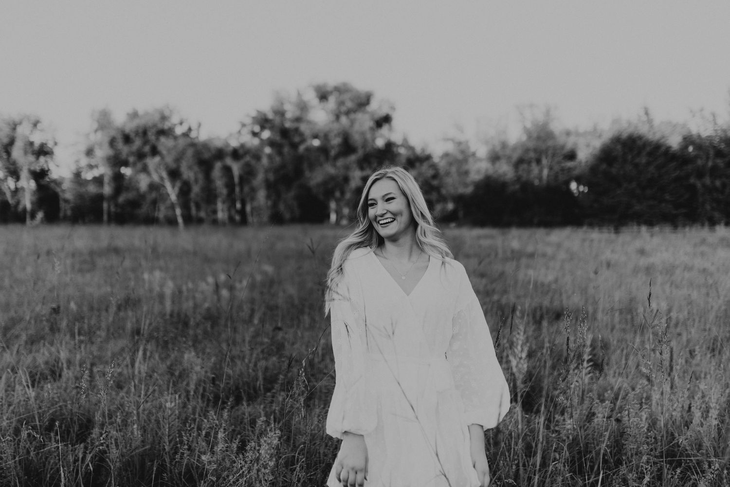 A dreamy black and white portrait taken in a field during golden hour.
