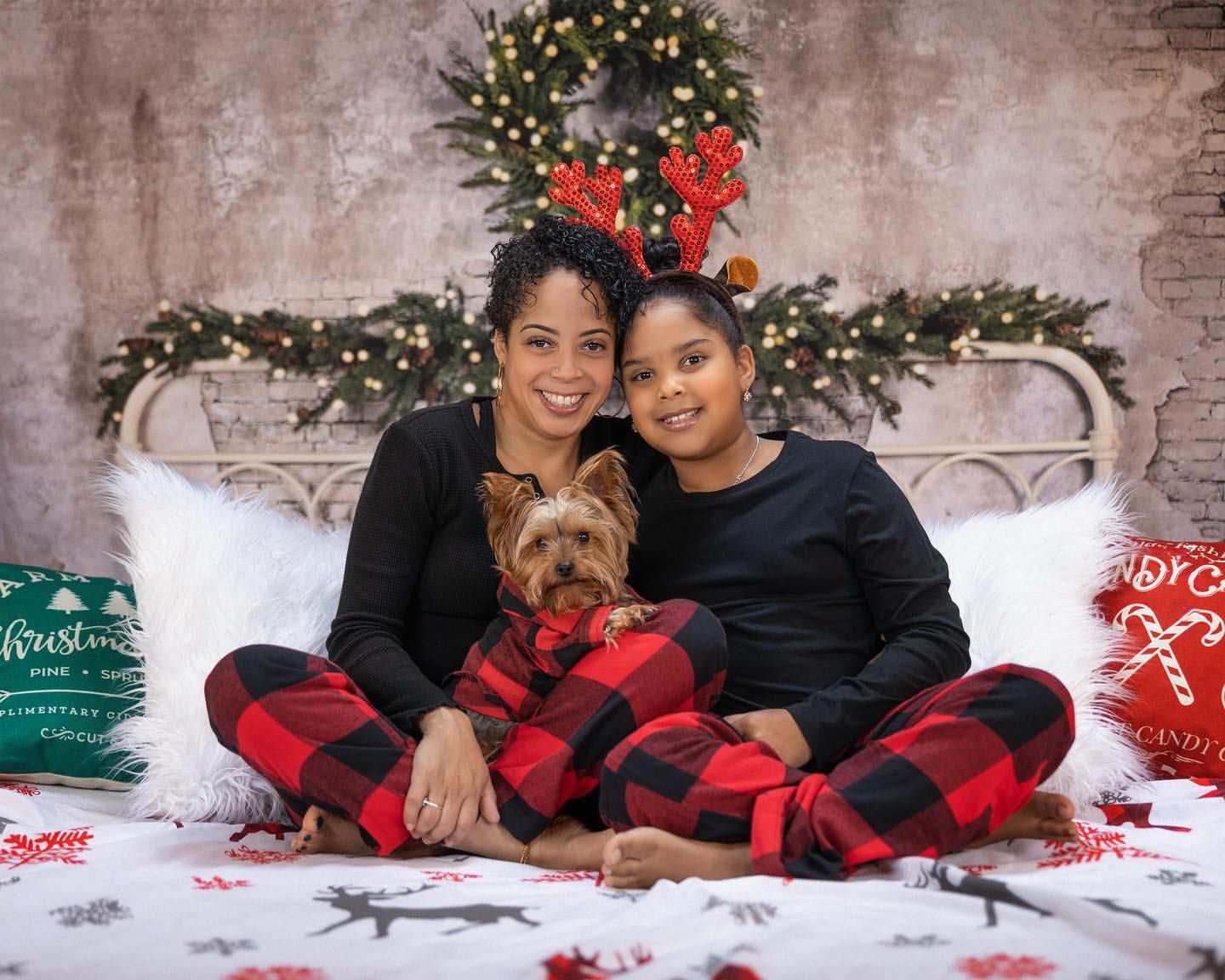 Cozy Christmas portrait with a Yorkshire terrier dog and matching buffalo plaid pajamas.