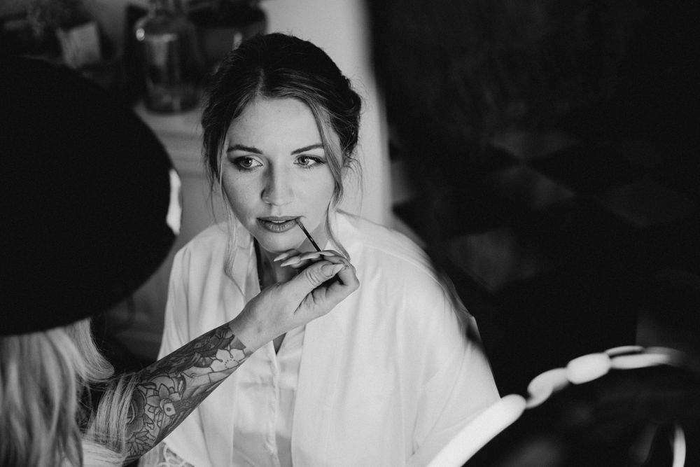 Black and white photo showing wedding preparations with emotional candid moments.