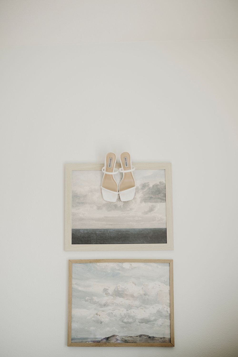 Minimalist wall art display featuring landscape paintings in light neutral tones.