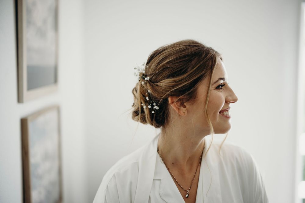 Elegant bridal preparation scene in bright white room with natural lighting.