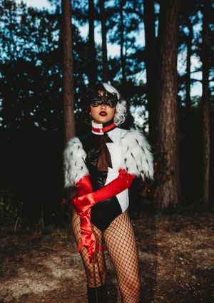 Fashion portrait featuring black and white fur coat with red accessories in a forest setting.