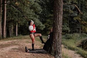 Artistic forest photoshoot with dramatic poses and gothic styling.