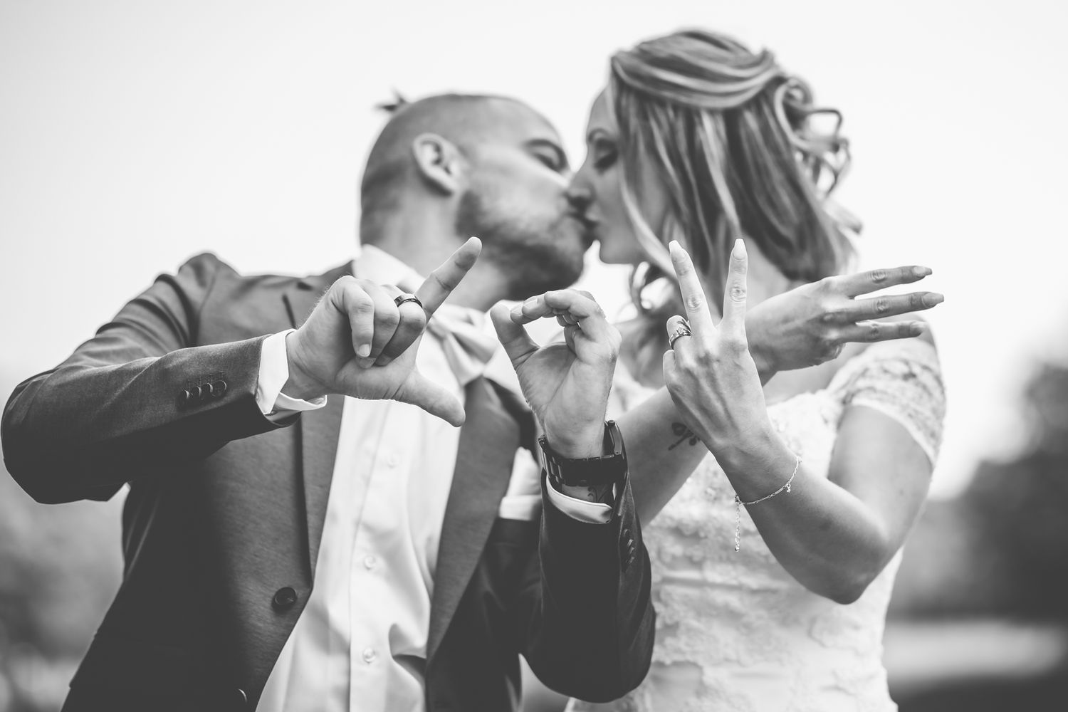 Bröllopsfotografering på Hjelmsjöborg i Örkelljunga där bröllopspar stava ut LOVE med fingarna.