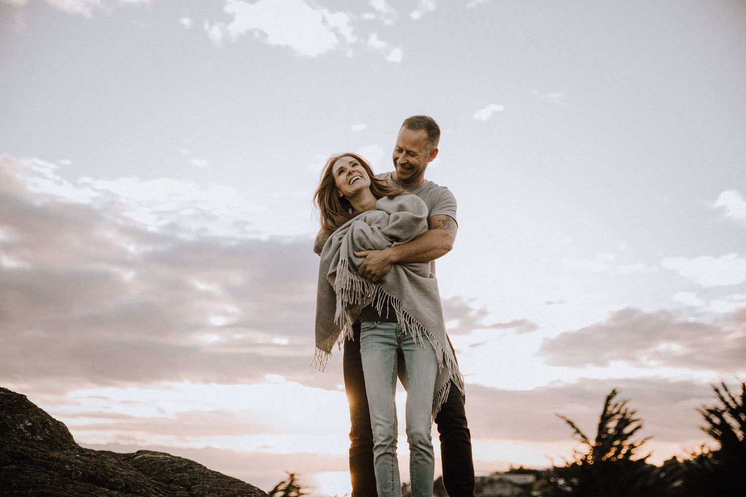 Couple holding each other and laughing at sunset