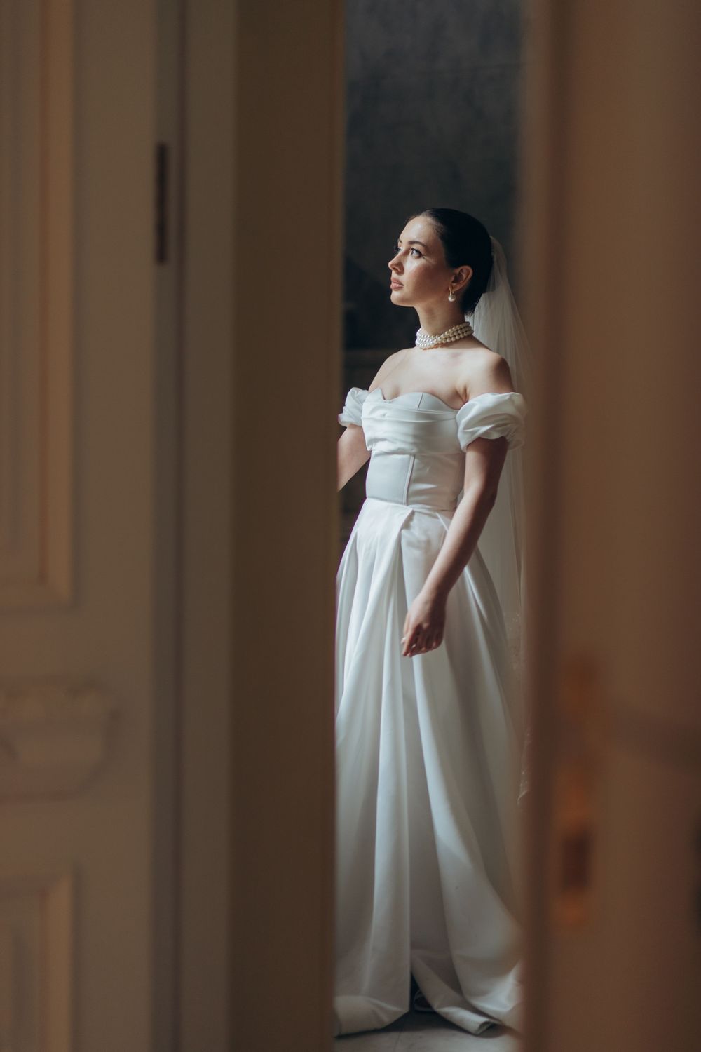 Minimalist bridal portrait featuring off-shoulder wedding dress with puff sleeves.