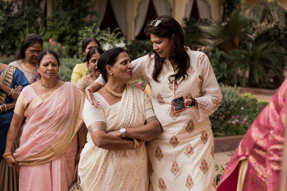 Group of women in traditional saris share joyful moment at cultural celebration.