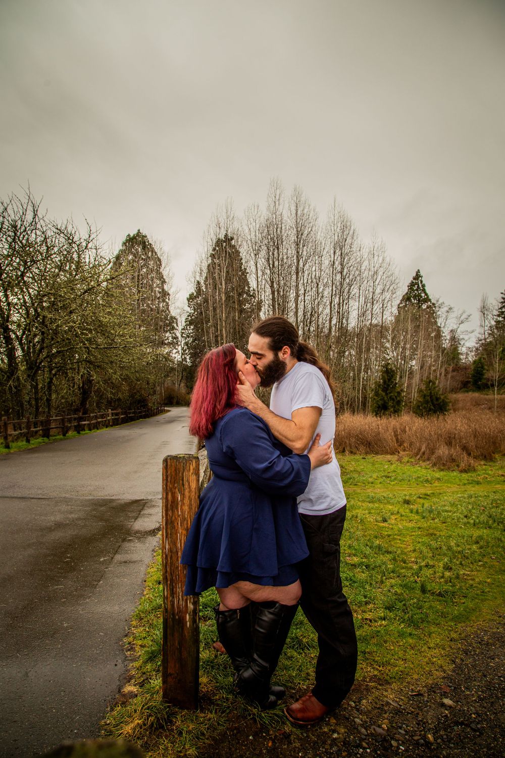 A romantic moment shared between two people on a tree-lined path.