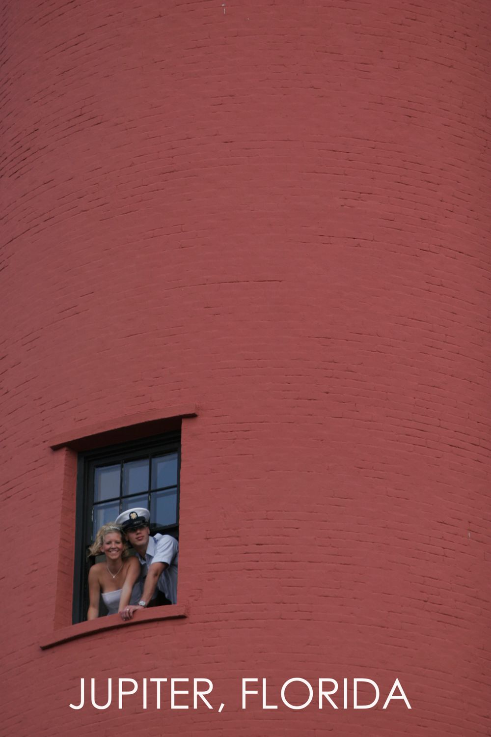 Red lighthouse window framed against textured wall in Jupiter, Florida.