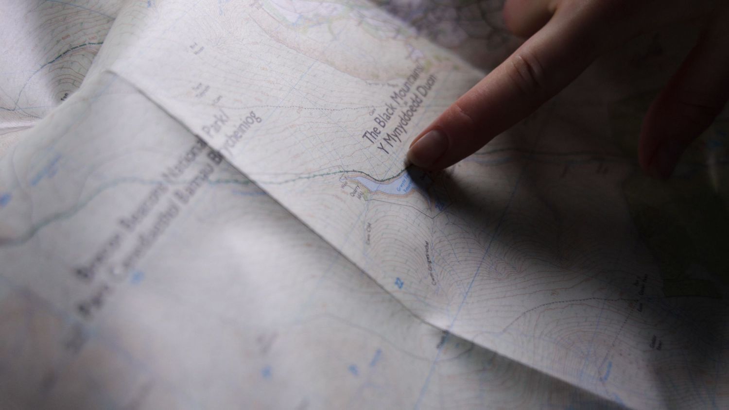 Close-up of finger pointing at navigation map details.