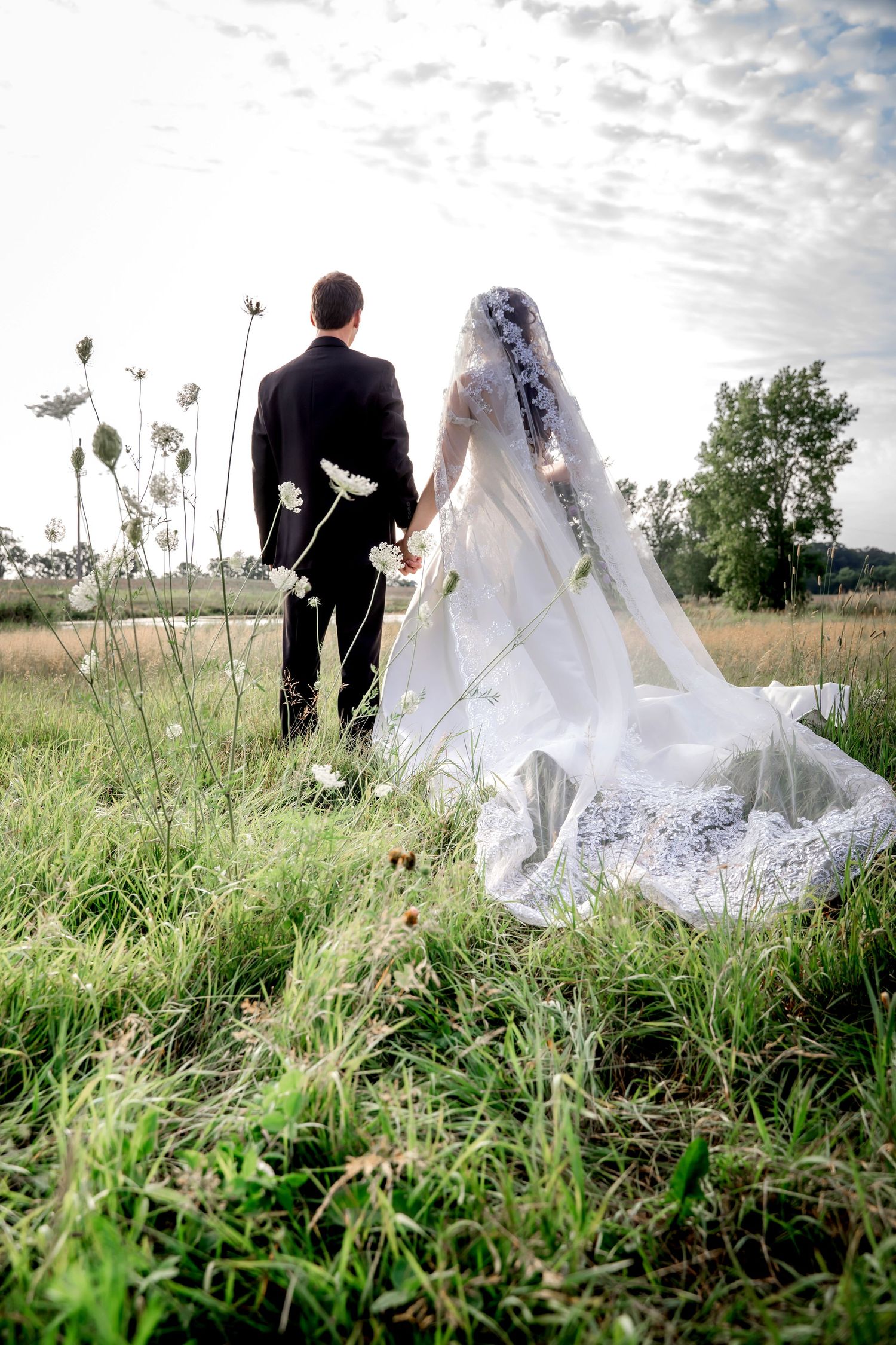 Bride and groom in a field with Queen Anne's Lace by Kalamazoo Wedding Photographer Almost Fantasy