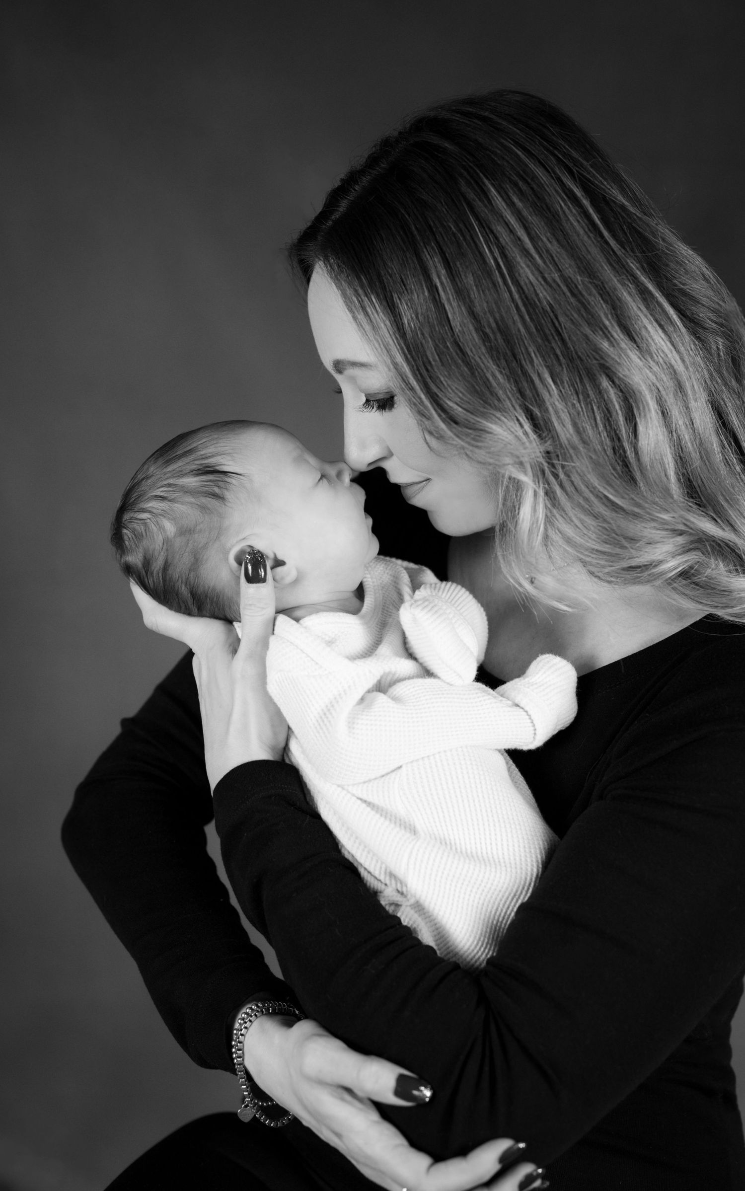 Black and white portrait series of tender moments between parent and baby.