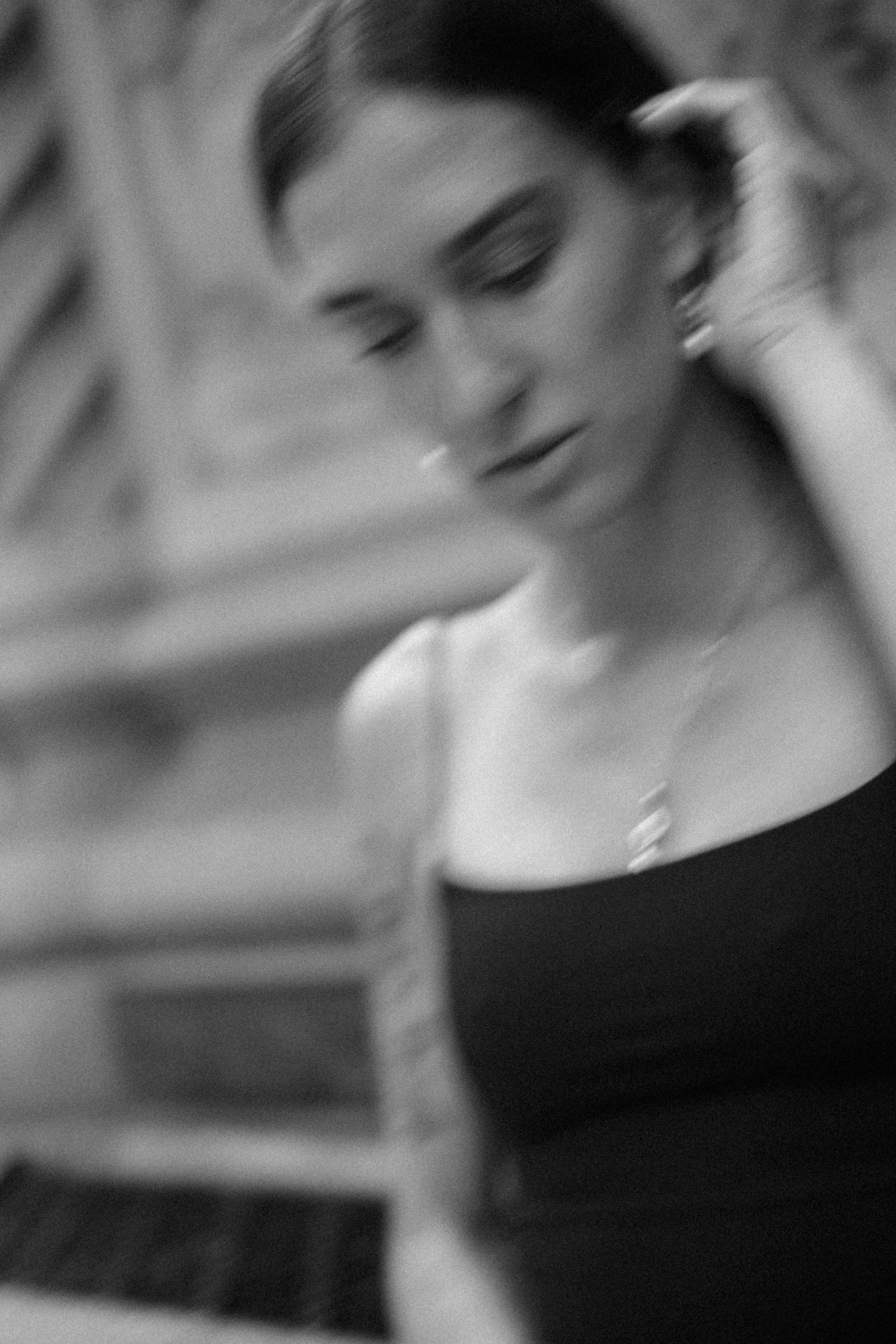 Artistic black and white portrait with soft focus showing figure in black top.