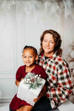 A festive holiday portrait with a silver wrapped present and winter decorations.