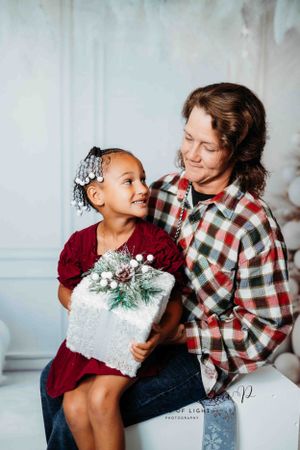 A heartwarming holiday portrait with decorative presents and winter themed backdrop.