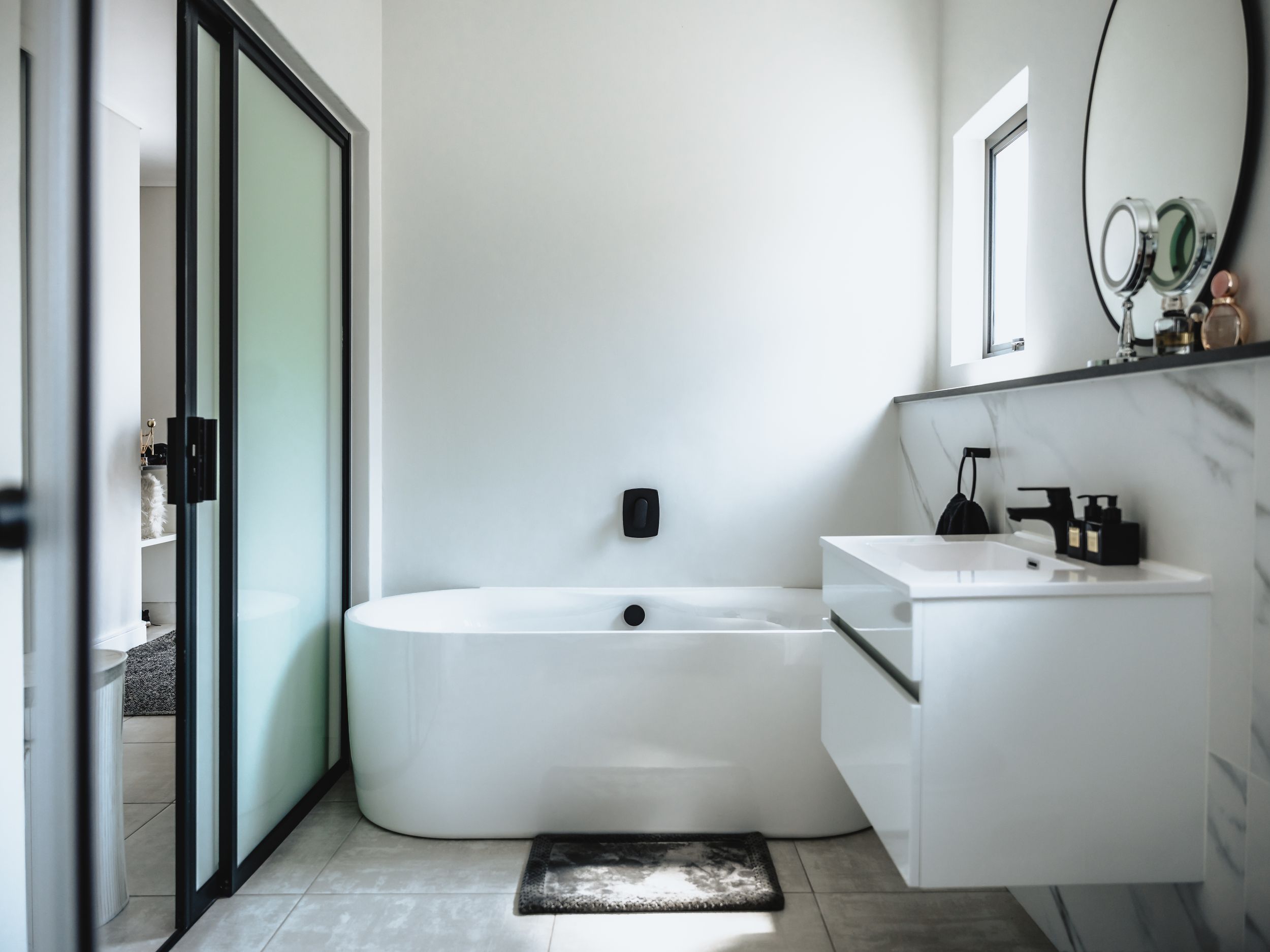 Contemporary bathroom with freestanding tub, floating vanity and frosted glass sliding door.