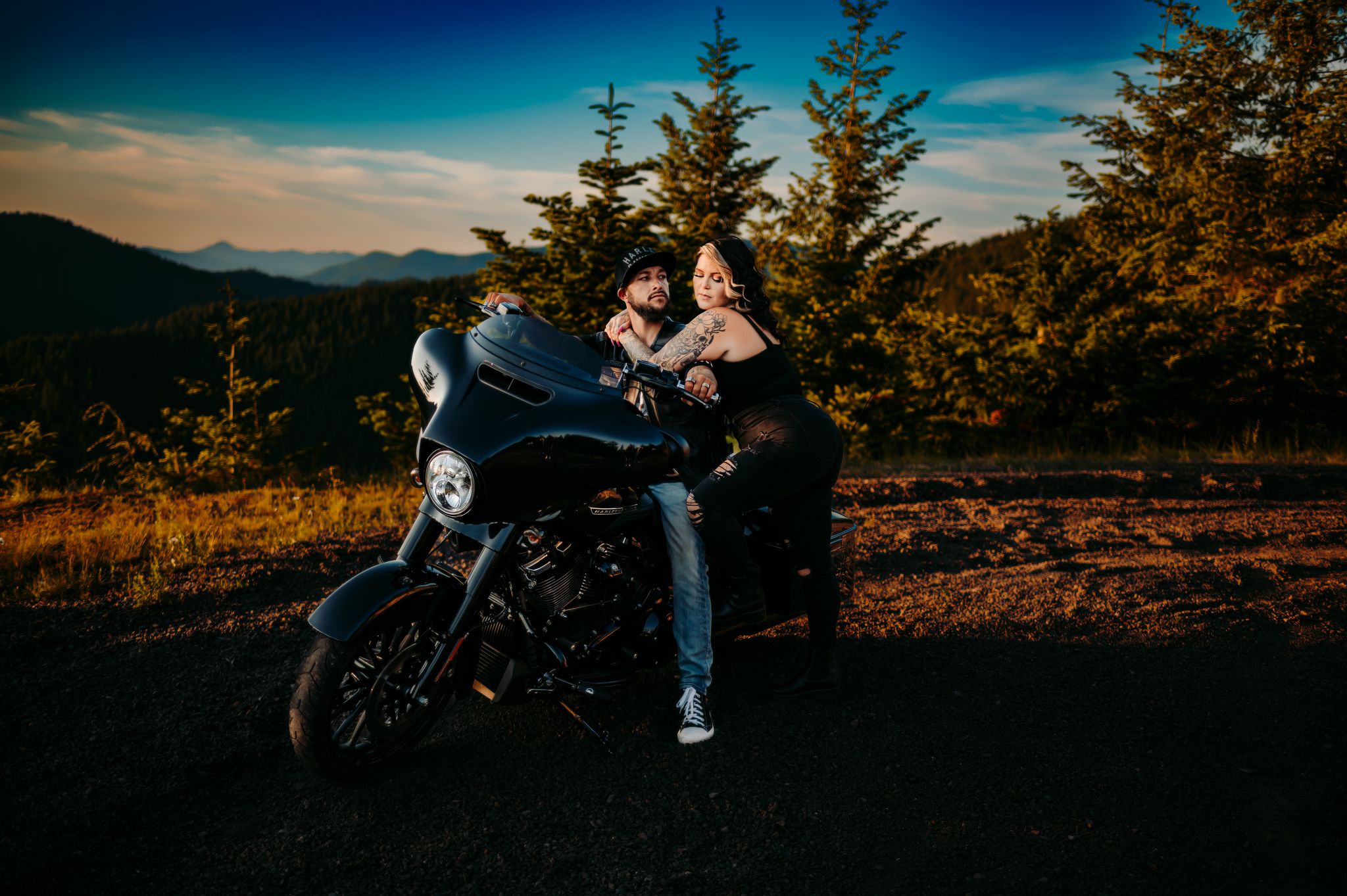 Motorcycle engagement photoshoot at sunset with mountain landscape in the background.
