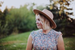 Candid outdoor portrait series showing someone in floral dress and wide-brim hat.