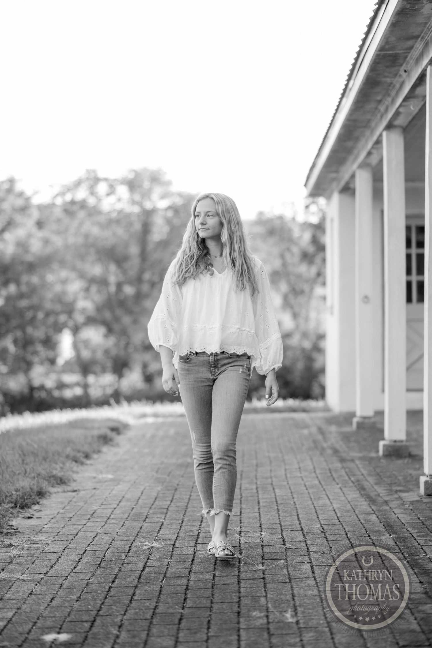 Black and white portrait on brick walkway showing movement and casual summer style.