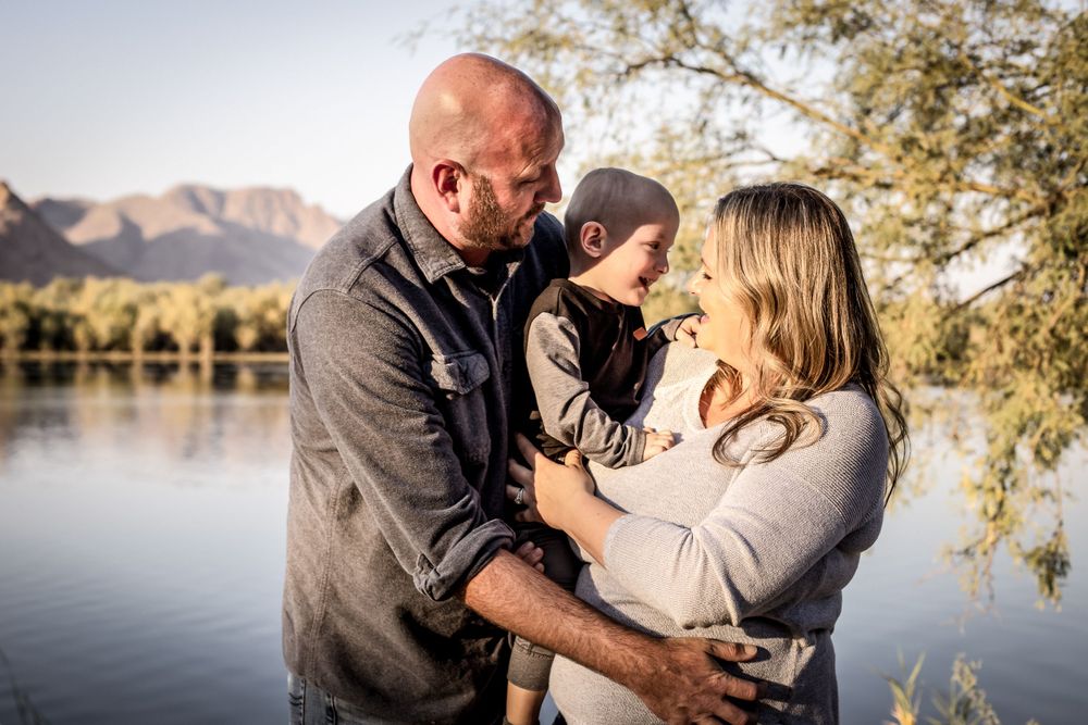 Natural outdoor family photography session with mountain and lake backdrop.