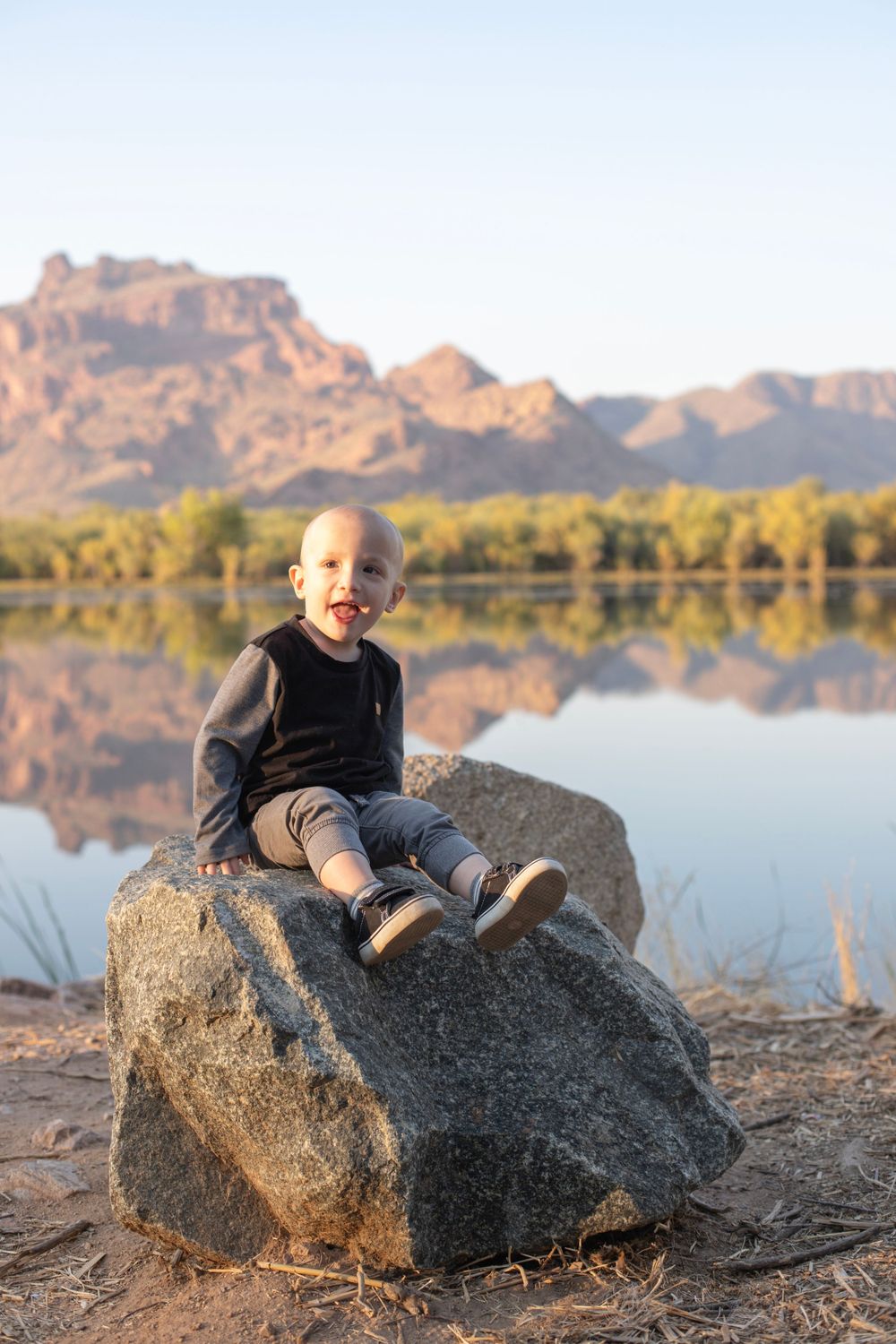 Desert landscape photography featuring rock formations and a reflective lake at sunset.