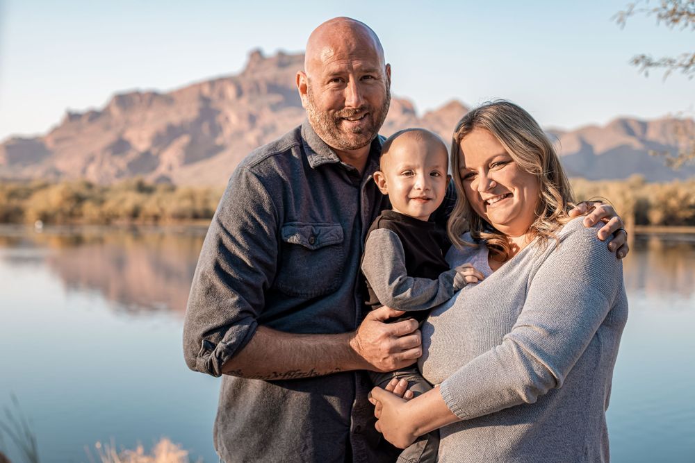 Loving family portrait session near a serene lake with desert mountains in view.