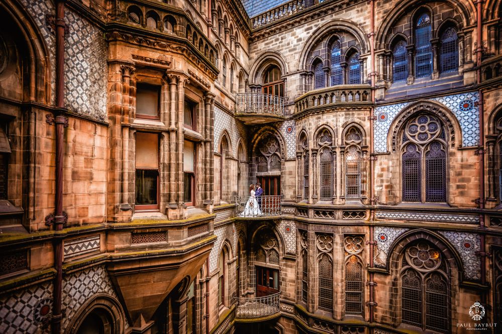 Ornate Gothic architecture interior with arched windows and detailed stone carvings in warm lighting.