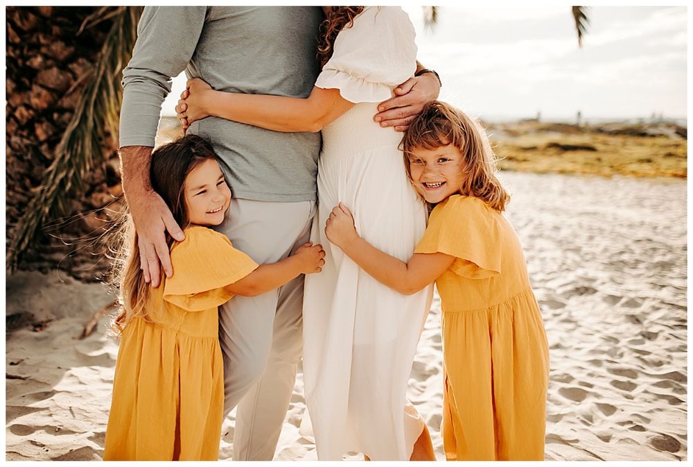 girls hug parents legs during Coronado mini session