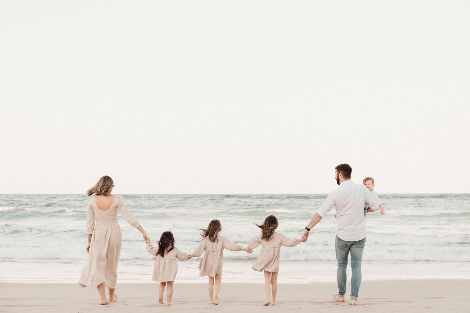 Family walking hand in hand along the picturesque Surfers Paradise Beach