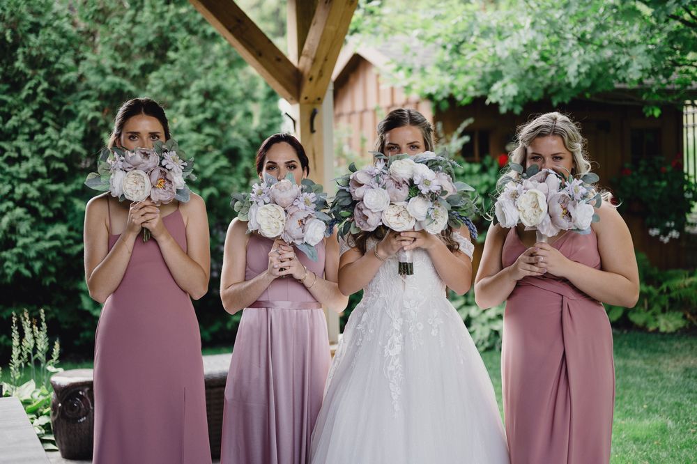 London Wedding Photographer Bride and Bridesmaids Hiding Behind Flowers Spirits Intrigued Photography 2022