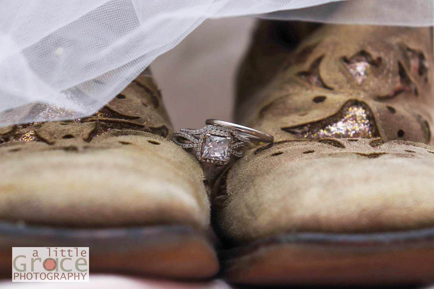 Vintage wedding shoes with lace and floral details arranged on white fabric.