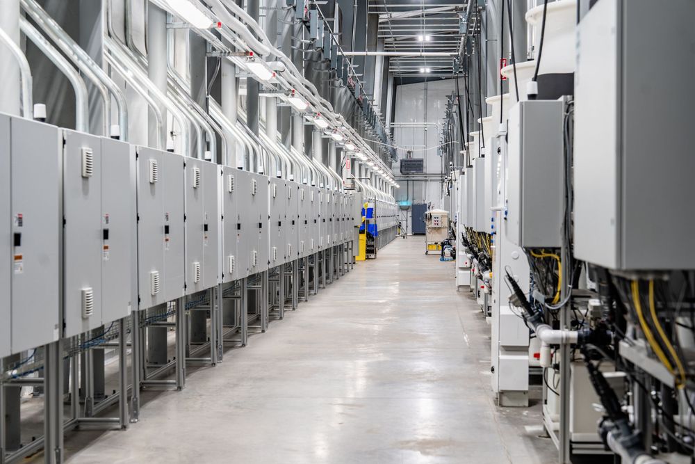 Long corridor view of an industrial facility with automated processing equipment.