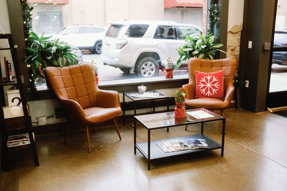 Contemporary office lobby with modern furniture, plants, and natural lighting.