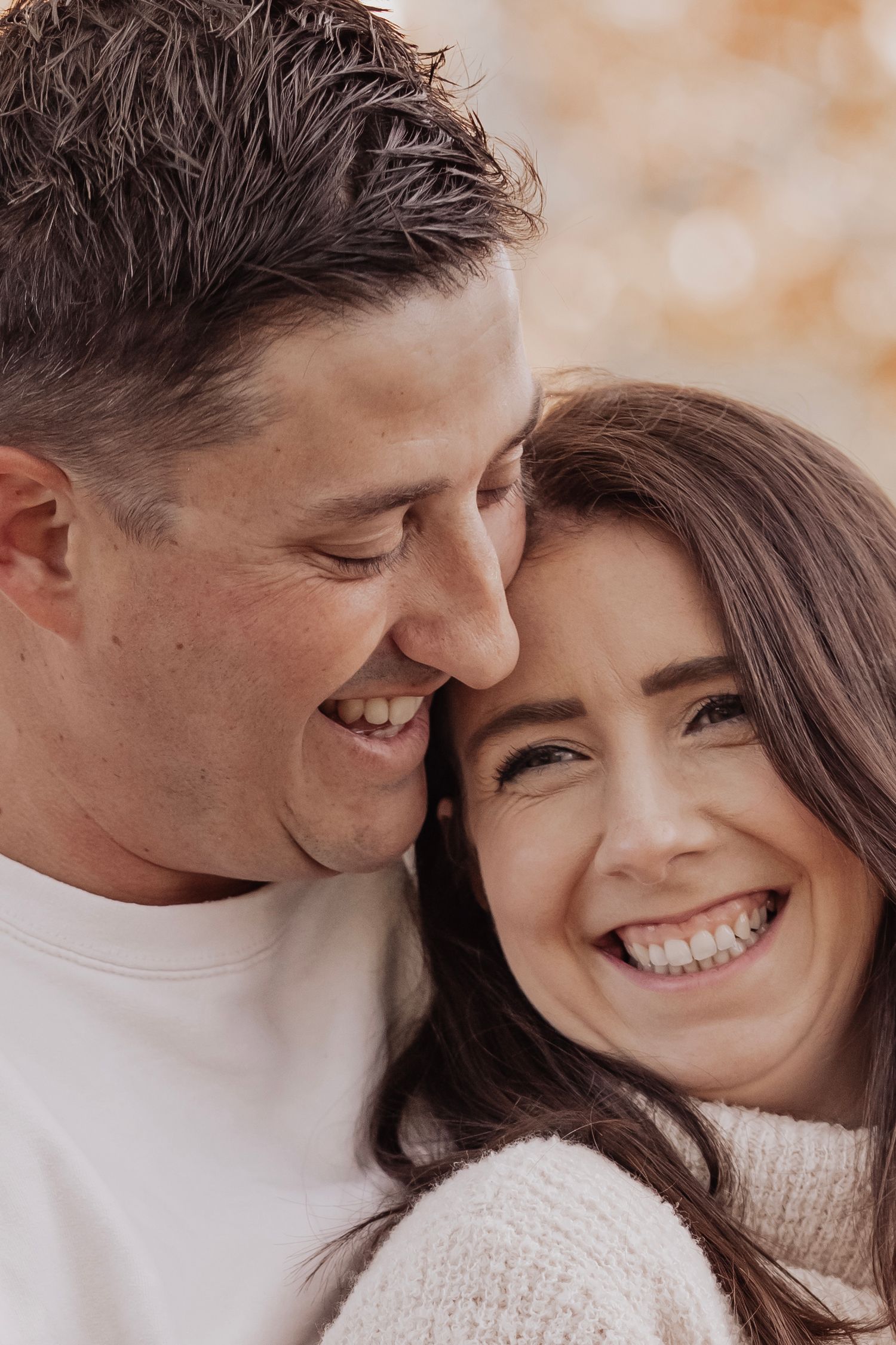 A joyful couple sharing a close intimate moment together while wearing winter sweaters.