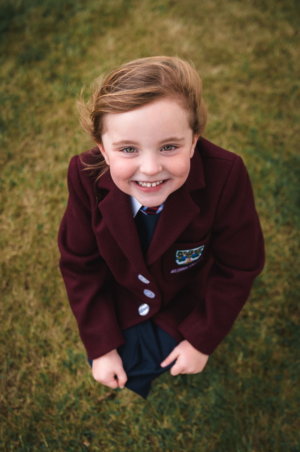 girl in school uniform looking up and smiling
