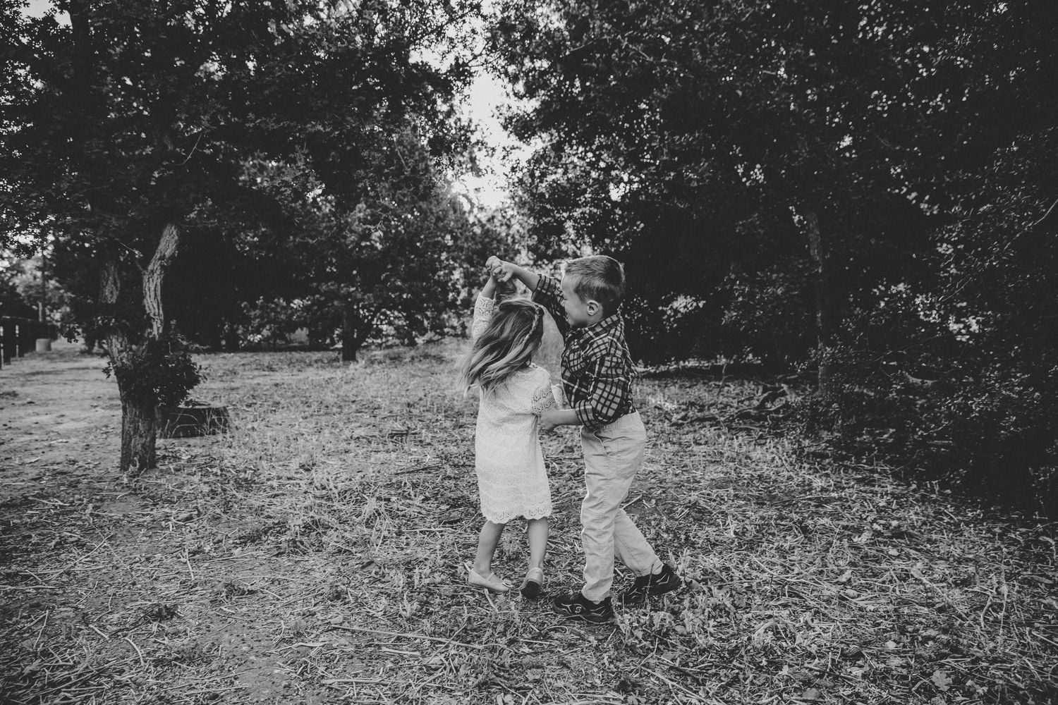Young boy twirling a young girl