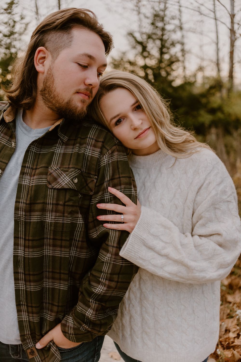 Intimate couple's photoshoot featuring cozy sweaters and plaid in natural lighting.