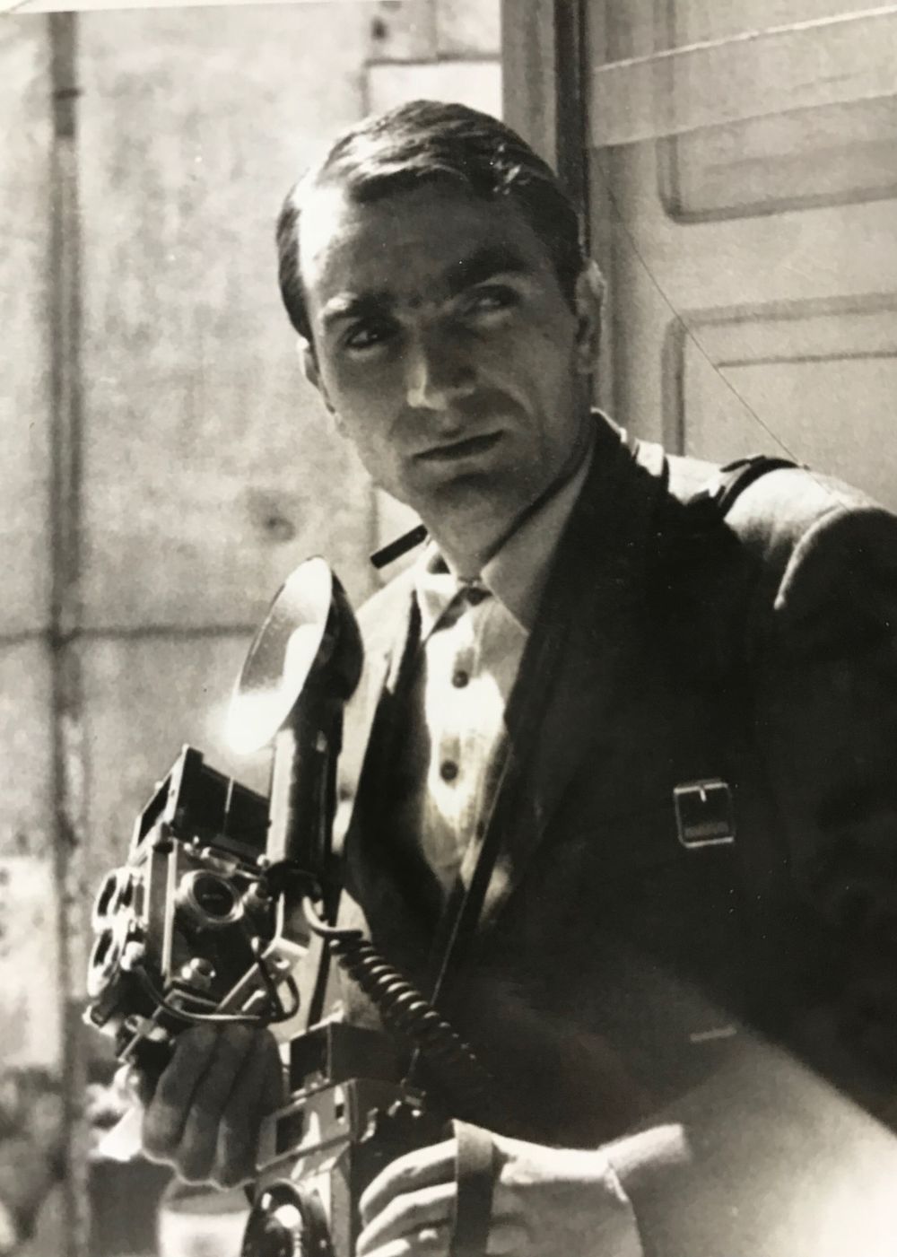 Photographers holding vintage cameras in black and white photograph.
