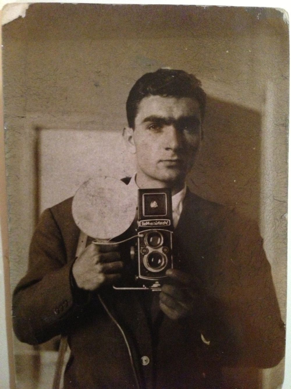 Vintage self-portrait photographs showing someone taking pictures with an old camera in sepia tones.
