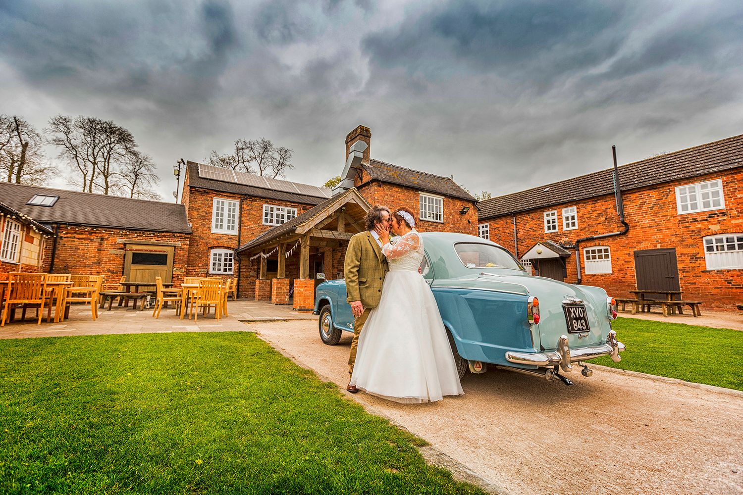 bride and groom by old morris car at Donnington park farm wedding photography